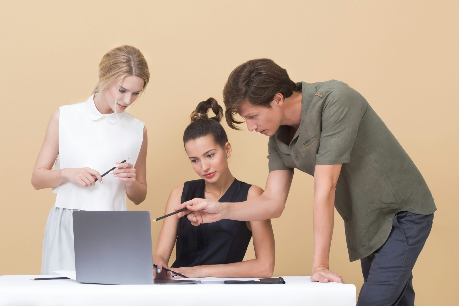 Drei Personen arbeiten zusammen am Laptop